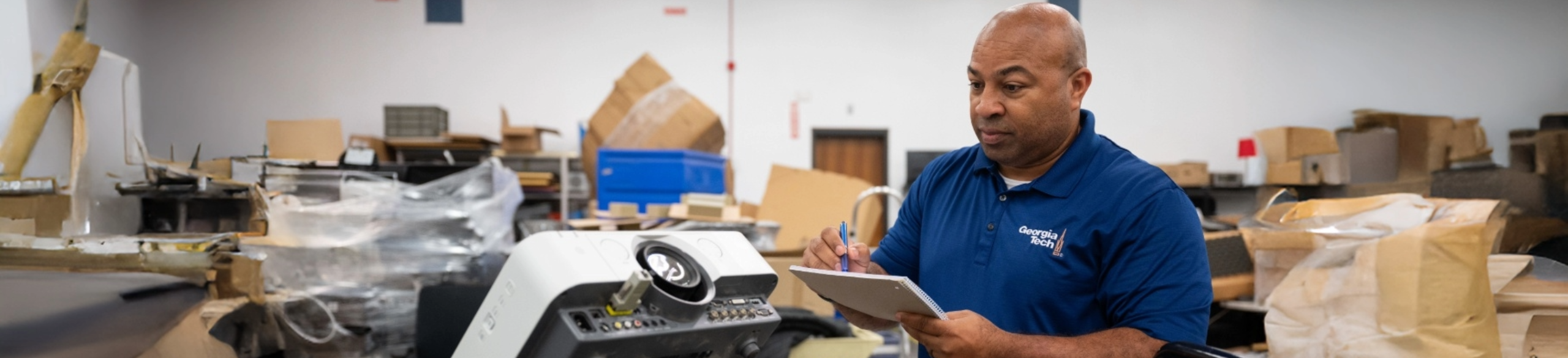 Man in navy polo working inside workshop